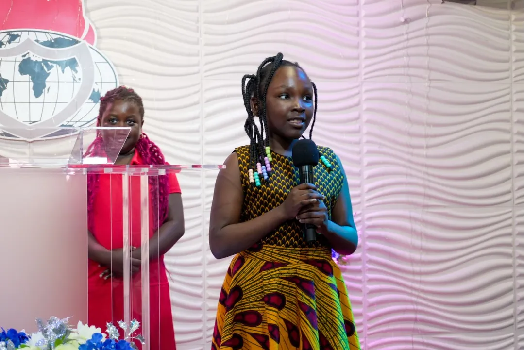 A girl singing at the front of the church