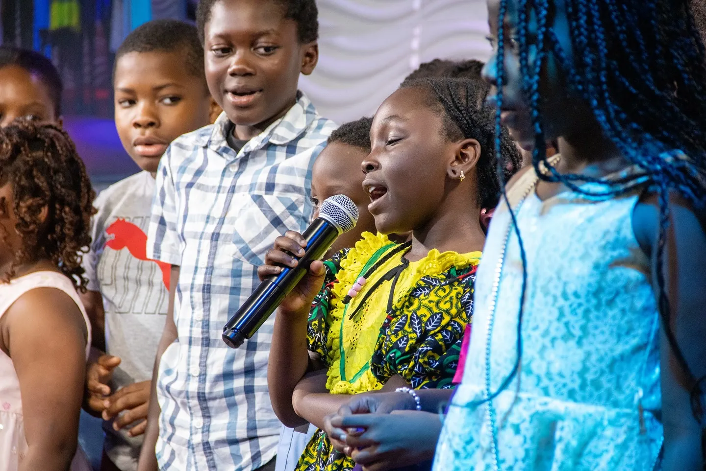 Children singing together during a covenant day service