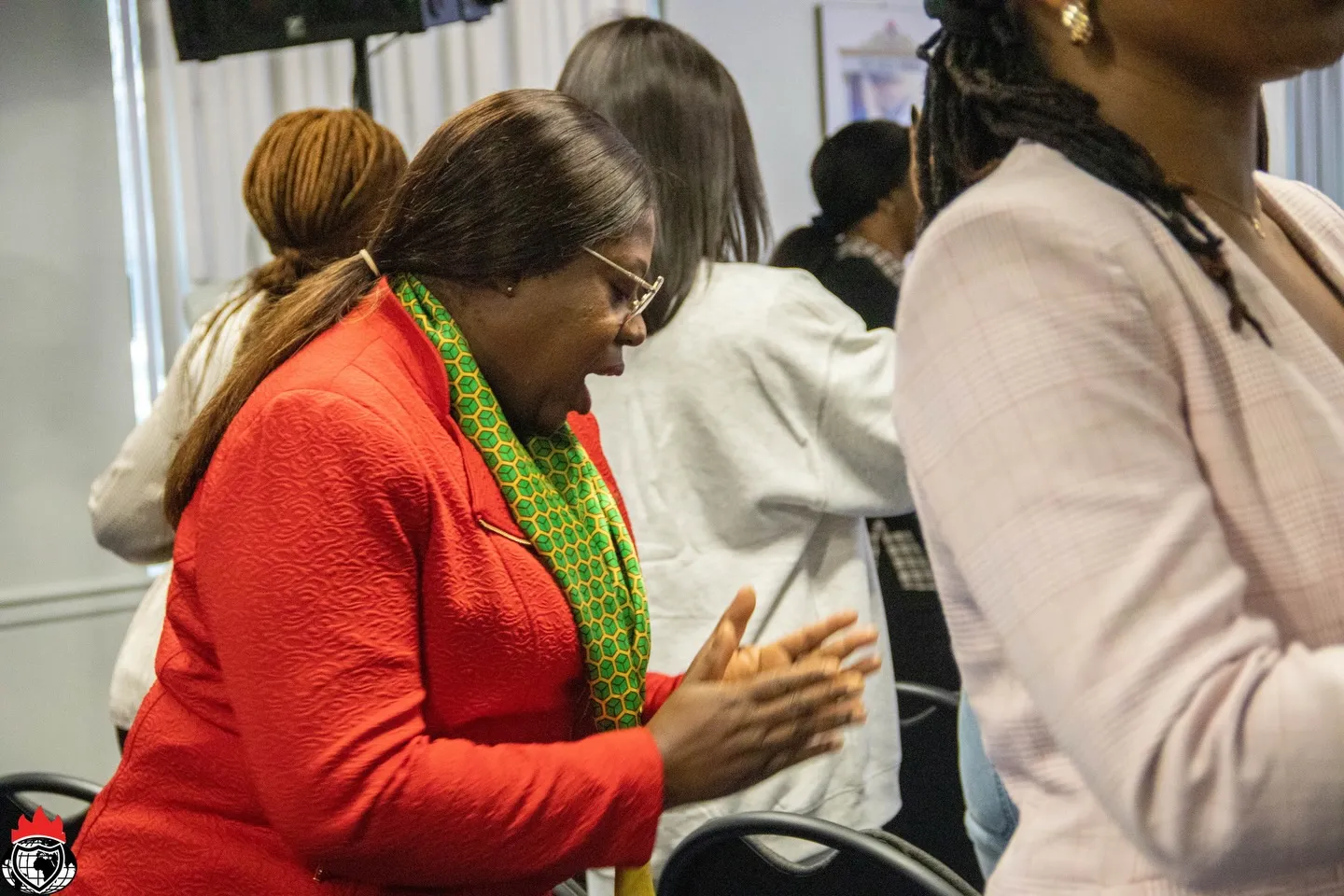 A member in red clapping with joy during worship