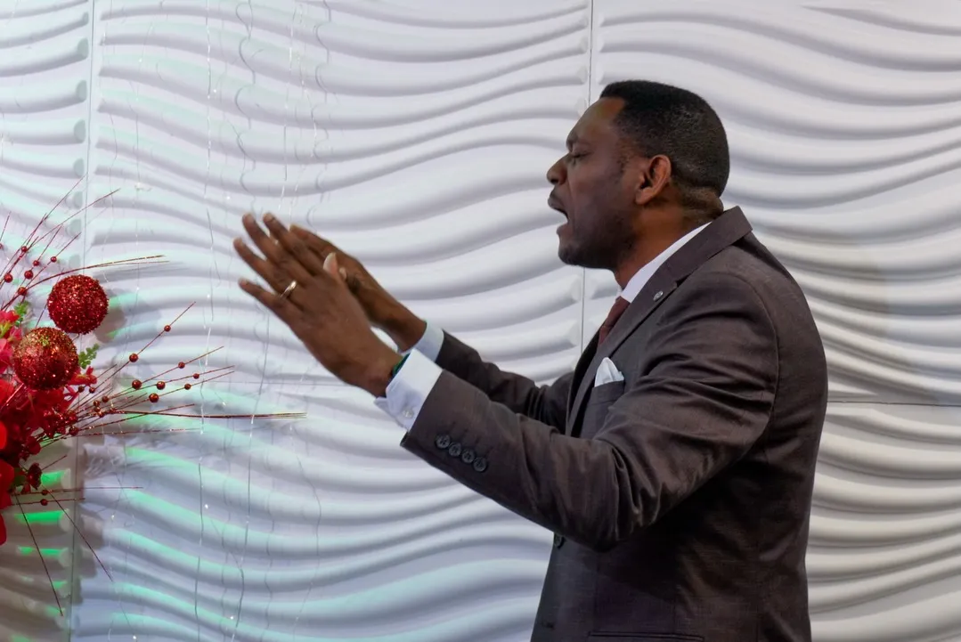 A minister praying with outstretched hands