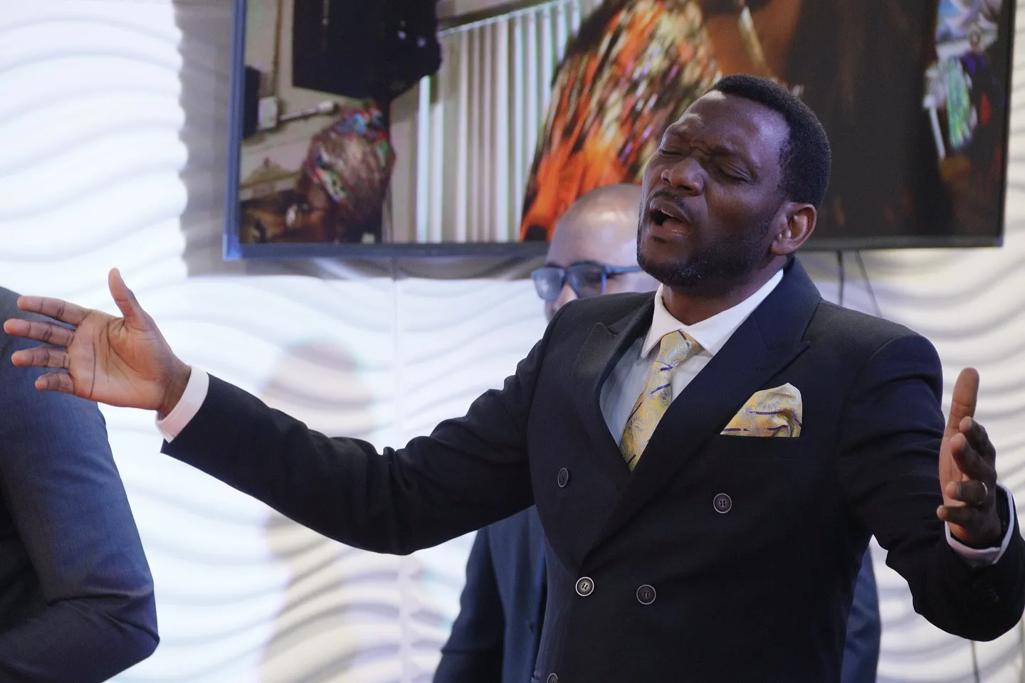 A minister preaching with arms open wide