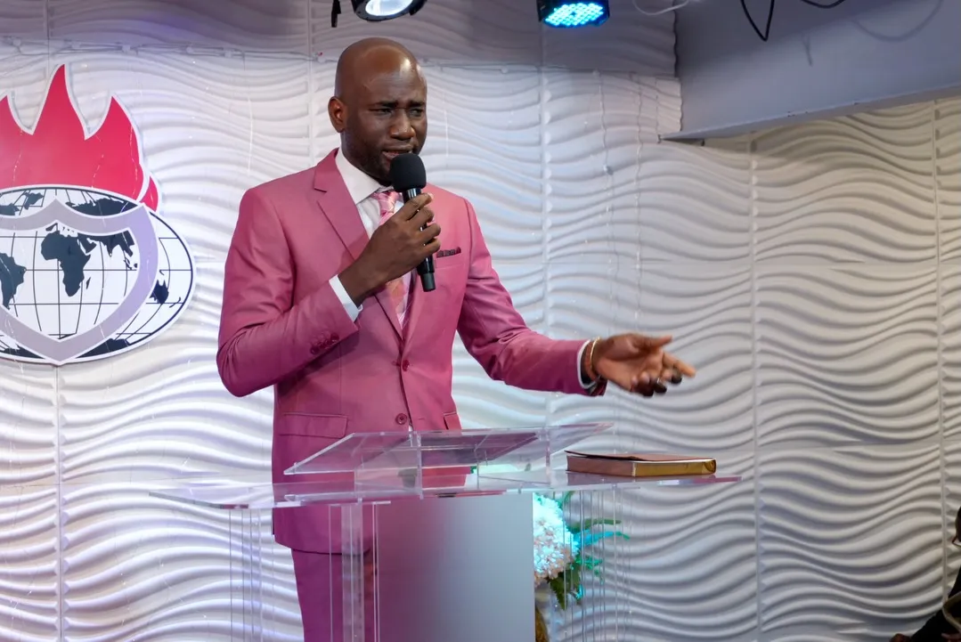 A minister in a pink suit preaching